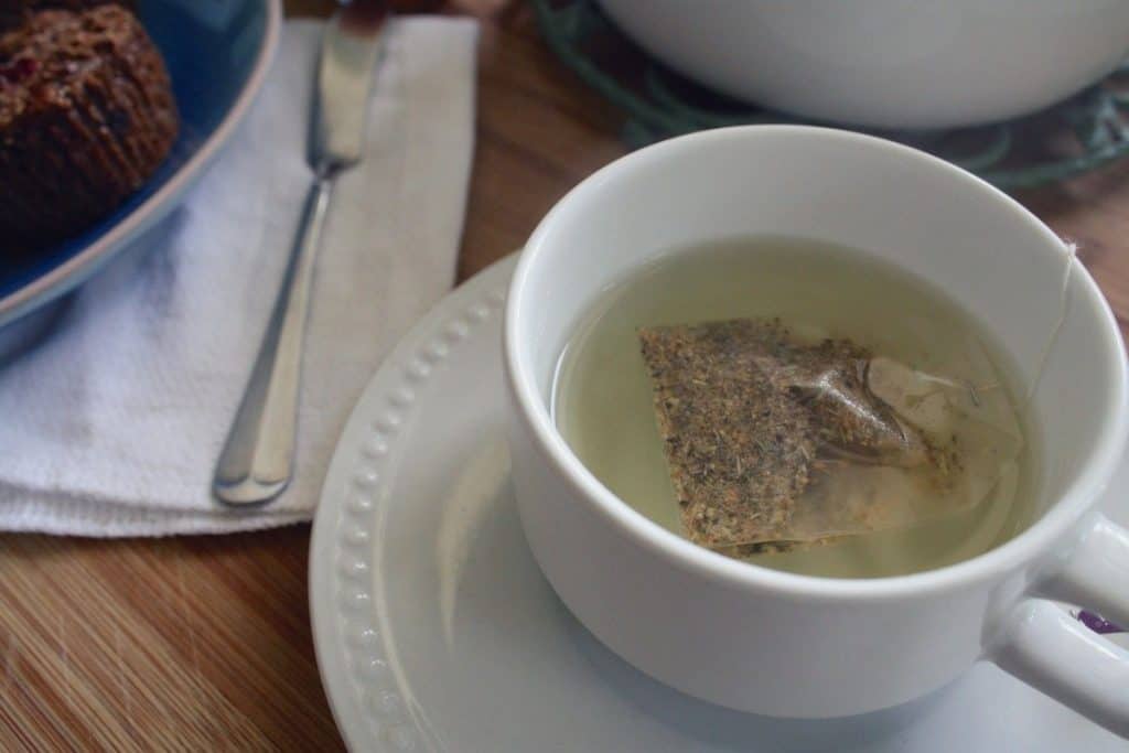 a cup of green tea with a teabag