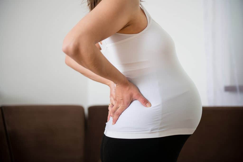 pregnant woman holding her painful back