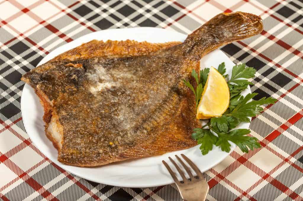 fried flounder with parsley and lemon on a plate