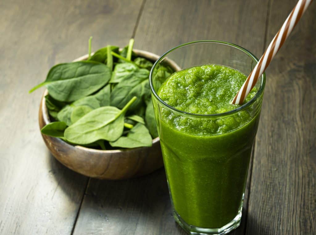 spinach smoothie in a glass on a table