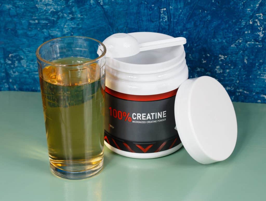 creatine powder pre-workout food supplement and a glass of grape juice