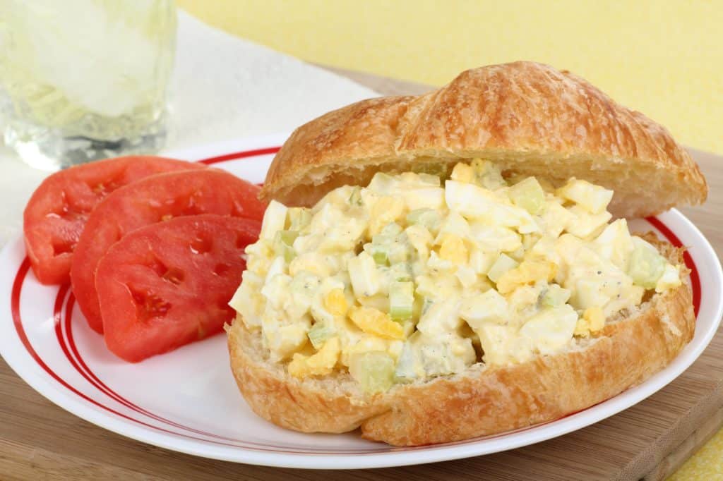Egg salad sandwich with tomato slices on a plate